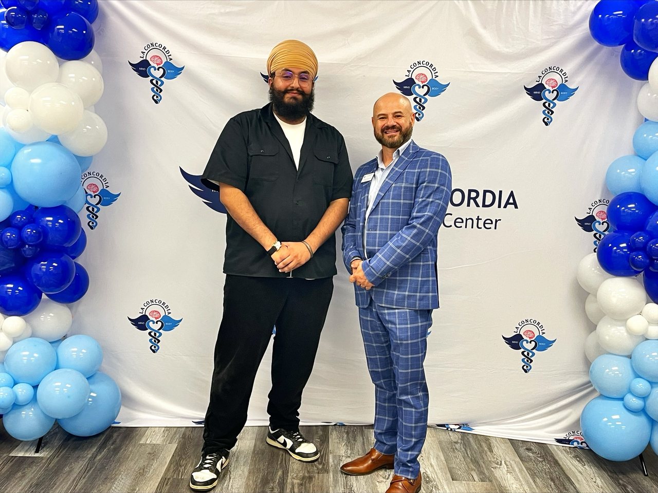 A guest with Dr. Manuel Fernandez at the La Concordia celebration backdrop