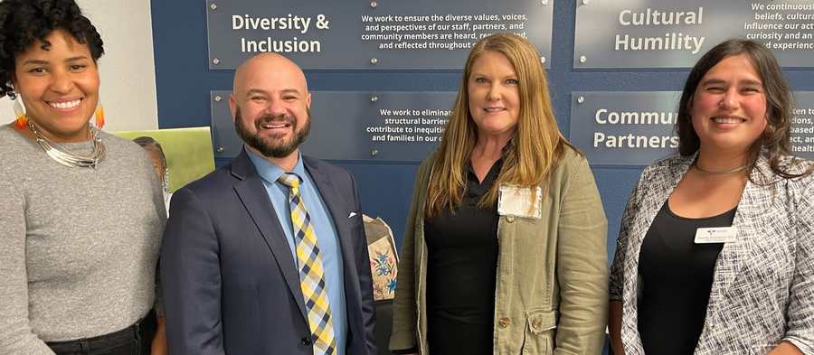 La Concordia team standing together in front of a wall reading Diversity and Inclusion, Cultural Humility, and Community Partners