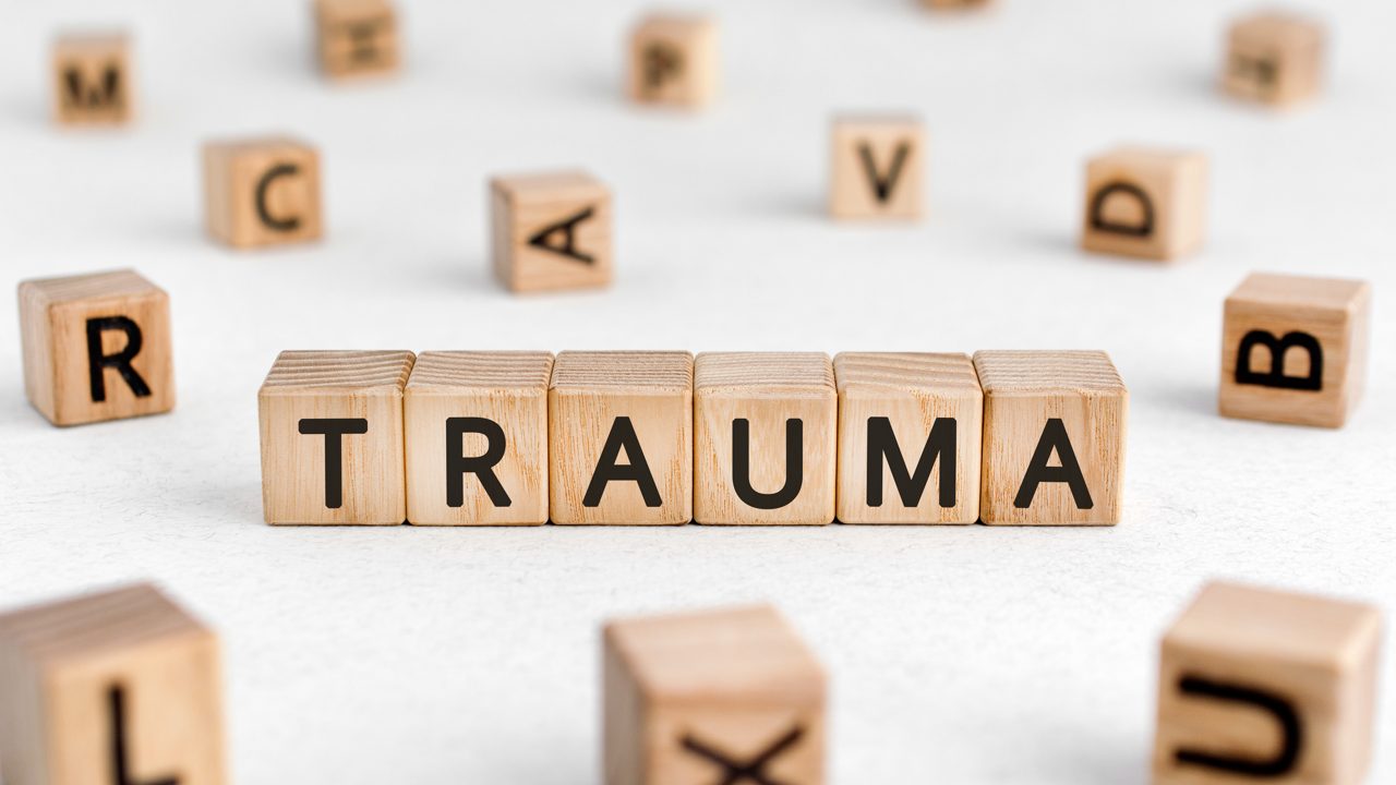 The word TRAUMA spelled out in tiles