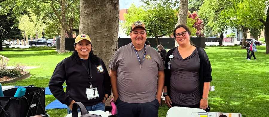 La Concordia staff at an information table during an outdoor community event